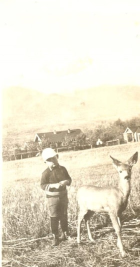 Arnie Berg standing with a deer in a field. (Images are provided for educational and research purposes only. Other use requires permission, please contact the Museum.) thumbnail