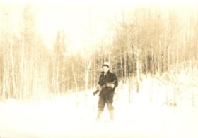 Barney Mulvainy snowshoeing through the woods with a shotgun in his hands. (Images are provided for educational and research purposes only. Other use requires permission, please contact the Museum.) thumbnail