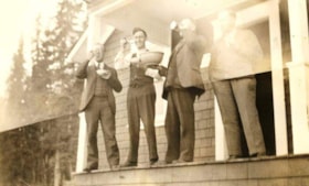 L.B. Warner (far left) and three other men standing outside on a porch. (Images are provided for educational and research purposes only. Other use requires permission, please contact the Museum.) thumbnail