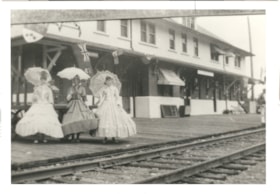 Three women in front of CNR stations dressed in hoopskirts and carrying parasols.. (Images are provided for educational and research purposes only. Other use requires permission, please contact the Museum.) thumbnail