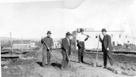 Four men standing with tools on Main Street, Smithers, B.C.. (Images are provided for educational and research purposes only. Other use requires permission, please contact the Museum.) thumbnail