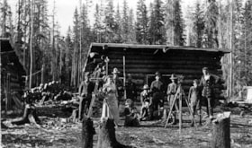 Group photo outside log cabins.. (Images are provided for educational and research purposes only. Other use requires permission, please contact the Museum.) thumbnail