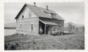 Man and boy standing in front of a house by Lake Kathlyn. (Images are provided for educational and research purposes only. Other use requires permission, please contact the Museum.) thumbnail