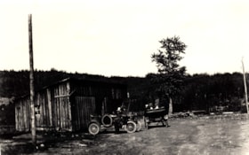 Unidentified men in cars outside a garage.. (Images are provided for educational and research purposes only. Other use requires permission, please contact the Museum.) thumbnail