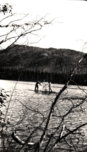 Four people on a raft on a lake.. (Images are provided for educational and research purposes only. Other use requires permission, please contact the Museum.) thumbnail