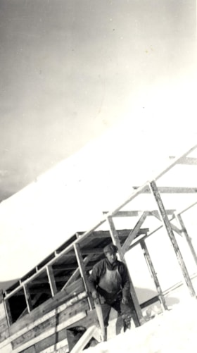Unidentified man near wooden structure. (Images are provided for educational and research purposes only. Other use requires permission, please contact the Museum.) thumbnail