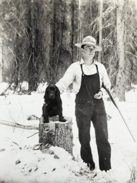 Unidentifed man with a rifle petting a dog on a stump. (Images are provided for educational and research purposes only. Other use requires permission, please contact the Museum.) thumbnail
