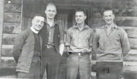 Four men in front of a log structure. (Images are provided for educational and research purposes only. Other use requires permission, please contact the Museum.) thumbnail