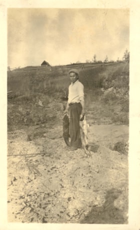Indigenous man holding salmon. (Images are provided for educational and research purposes only. Other use requires permission, please contact the Museum.) thumbnail