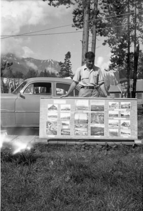 Man with display of old photographs. (Images are provided for educational and research purposes only. Other use requires permission, please contact the Museum.) thumbnail