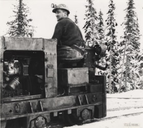 Man seated on vehicle in snow. (Images are provided for educational and research purposes only. Other use requires permission, please contact the Museum.) thumbnail
