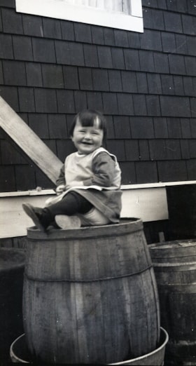 Child sitting on barrel. (Images are provided for educational and research purposes only. Other use requires permission, please contact the Museum.) thumbnail
