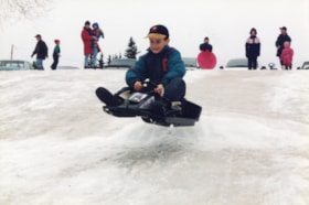 Boy sledding at Knights of Columbus toboggan party. (Images are provided for educational and research purposes only. Other use requires permission, please contact the Museum.) thumbnail