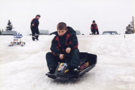 Boy sledding at Knights of Columbus toboggan party. (Images are provided for educational and research purposes only. Other use requires permission, please contact the Museum.) thumbnail