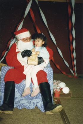 Little girl on Santa's lap. (Images are provided for educational and research purposes only. Other use requires permission, please contact the Museum.) thumbnail