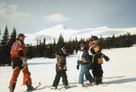 Coach and three kids at ski school. (Images are provided for educational and research purposes only. Other use requires permission, please contact the Museum.) thumbnail